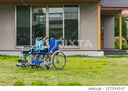 住宅の前に置かれた二つの車椅子 127354147