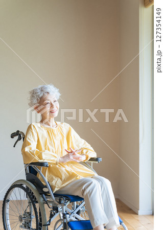 車椅子に乗ってリラックスするシニア女性 車椅子に乗ってリラックスするシニア女性 127354149