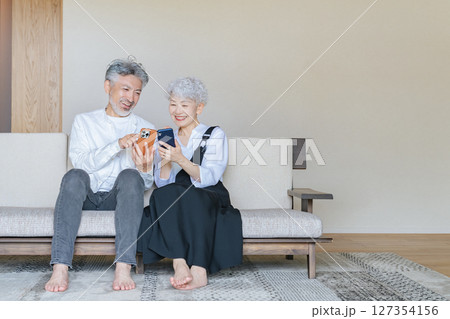 一緒にスマホを見るシニアカップル 127354156