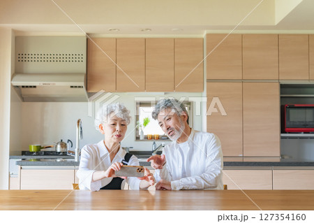 一緒にスマホを見るシニアカップル 127354160