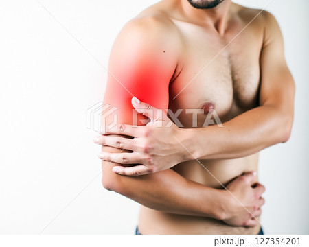 Man experiencing arm pain with visible redness in the elbow area while standing indoors 127354201