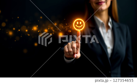 Professional woman using touch screen to display glowing smiley face in a dark environment during evening hours Professional woman using touch screen to display glowing smiley face in a dark environment during evening hours 127354655