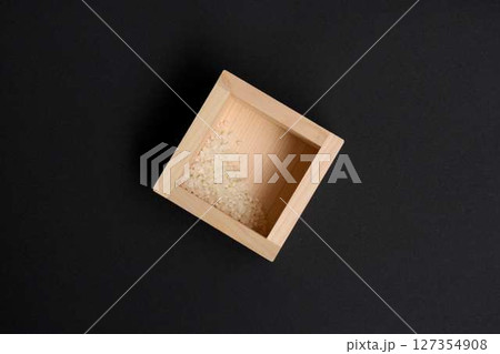 黒背景に升に残った少量のコメ 127354908
