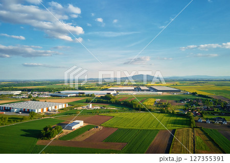 Aerial view of logistics center surrounded by farmland and countryside homes Aerial view of logistics center surrounded by farmland and countryside homes 127355391