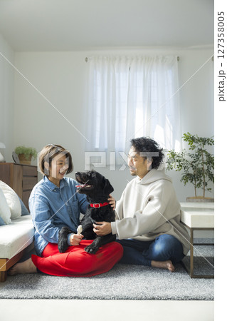 愛犬とくつろぐ夫婦 127358005