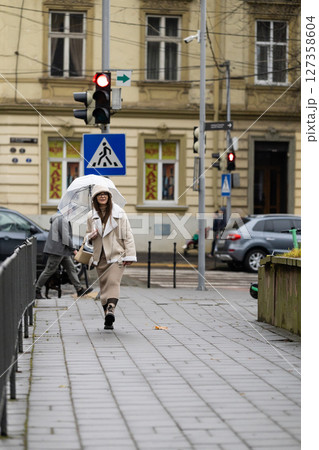 Life in the city on a rainy afternoon with umbrellas and gentle footsteps on wet pavement in a lively urban environment Life in the city on a rainy afternoon with umbrellas and gentle footsteps on wet pavement in a lively urban environment 127358604