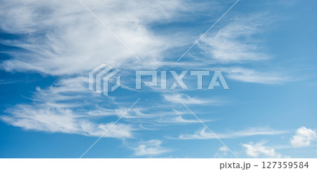 Soft white cirrus clouds against the blue sky 127359584