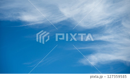 Soft white cirrus clouds against the blue sky 127359585