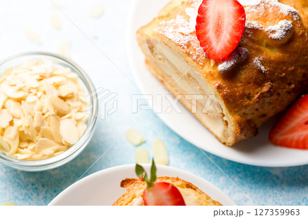 Sliced rolls with custard. The dessert is decorated with fresh strawberries. Sliced rolls with custard. The dessert is decorated with fresh strawberries. 127359963