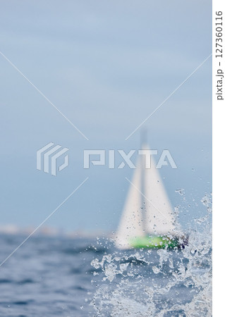 Sailing regatta in the Gulf of Finland at sunset, sailing yacht competing in a race, splashing water from under the boat, teamwork, board the boat 127360116