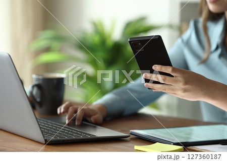 Businesswoman hands using multiple devices on a wooden table Businesswoman hands using multiple devices on a wooden table 127360187