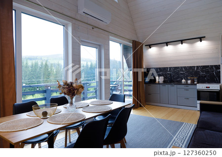 Modern Cozy Kitchen and Dining Area with Stunning Views of Nature, Perfect for Relaxation and Gatherings in This Stylish Cabin Retreat in the Mountains 127360250