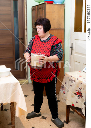 Baking passion flourishes in a cozy kitchen as a dedicated home chef prepares dough for delicious pastries in her cheerful apron Baking passion flourishes in a cozy kitchen as a dedicated home chef prepares dough for delicious pastries in her cheerful apron 127360333