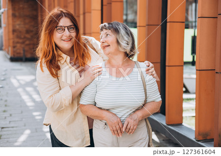 Senior Woman With Adult Daughter posing outdoors 127361604