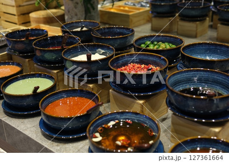 Sauces condiments utensils various spices and additives for oriental asian soup cabbage lime meat in blue plates with spoons in buffet Sauces condiments utensils various spices and additives for oriental asian soup cabbage lime meat in blue plates with spoons in buffet 127361664