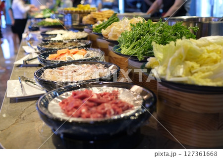 Fresh ingredients display Vibrant street food market in Bangkok, ingredients displayed on banana leaves. Thai vendor wearing black glove prepares traditional Asian dish, mixing spices and noodles 127361668