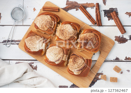 Kanelbulle Cinnamon buns with buttercream on a rustic wooden table. Homemade fresh pastries. top view, copy space. 127362467