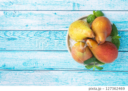 Fresh juicy Pears Conference on blue wooden bright background. Autumn harvest of ripe fruit. copy space 127362469