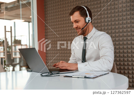 Using laptop. Handsome man in formal clothes is in the office 127362597