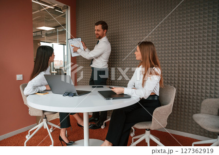 Manager is showing the plan project. Three business people are working in the office together Manager is showing the plan project. Three business people are working in the office together 127362919