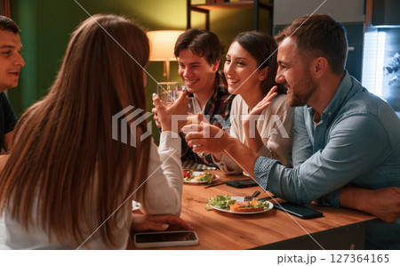 Group of people are on the kitchen, having dinner, spending time together Group of people are on the kitchen, having dinner, spending time together 127364165