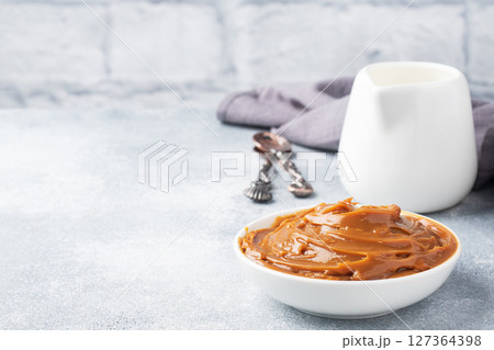 Boiled condensed milk in a plate. Sweet pasta spread for Breakfast and dessert. Copy space. 127364398