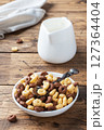 Dry breakfast cereals. Chocolate and corn rings made from natural cereals with milk in a plate. Wooden rustic background, copy space. 127364404