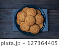 Natural homemade oatmeal cookies on a plate, dark wooden background, copy space. 127364405