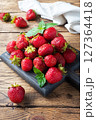handful Juicy ripe strawberries on a wooden rustic background. Sweet healthy dessert, vitamin harvest. copy space. 127364418