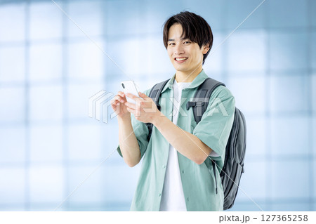 オフィスのロビーでスマホを持つ大学生 127365258