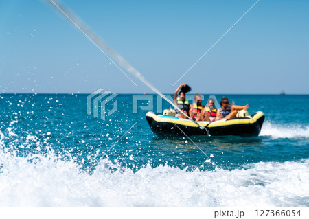 A group of friend having fun behind a speedboad on the sea 127366054