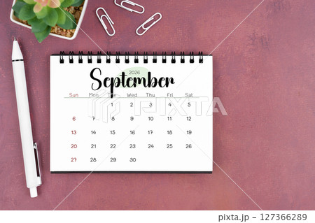 September desk calendar for 2026 year and pen on old red cover. Flat lay. 127366289