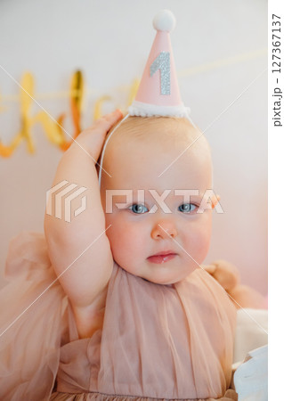 A little girl is unhappy that she was wearing a holiday cap. A little girl is unhappy that she was wearing a holiday cap. 127367137