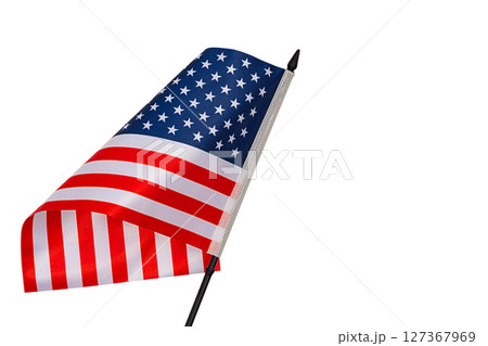 Stars striped blue red white flag of United States with black plastic post tilted forward and with curved canvas wriggling in wind is isolated on white background. Blank for holidays art works 127367969