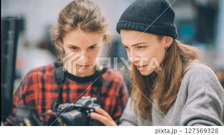 Female photographer teaches studio setup to student, World Photography Day concept 127369328