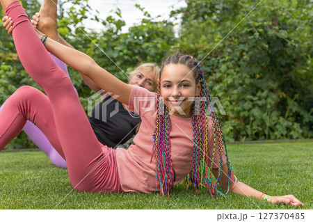 Closeup view of young girl and mature woman exercising gymnastics Closeup view of young girl and mature woman exercising gymnastics 127370485