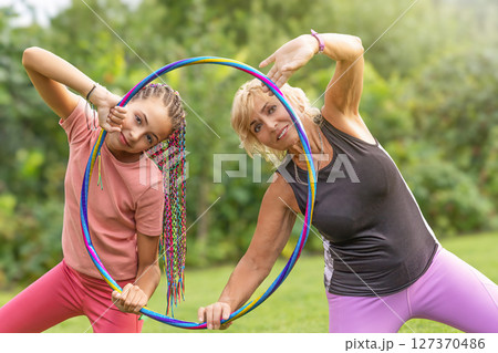 Girl and mature woman are holding gymnastic hoop 127370486