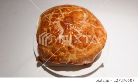 Close up of isolated baked puff pastry onion soup with golden crispy puff Close up of isolated baked puff pastry onion soup with golden crispy puff 127370507