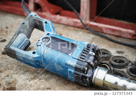 Power tool on a construction site showing wear and dirt after heavy use during a project in progress 127371343