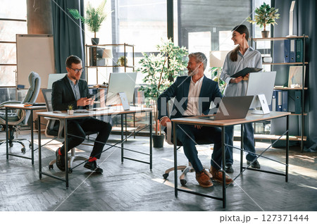 Using the pc's, sitting. Group of business people are working in the modern office 127371444