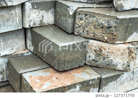 Stacked concrete bricks in a construction site during daylight hours in an urban environment 127371750