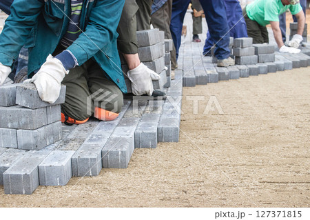 Volunteers constructing a pathway using concrete blocks during a community improvement project in spring 127371815