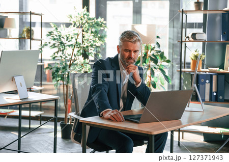 Senior businessman is working in the office Senior businessman is working in the office 127371943