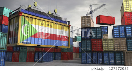 Cargo container with flag of Comoros lifted by crane at freight terminal - 3D illustration 127372085