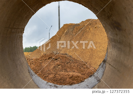 Soil excavation at the construction site. A pile of sand and earth after earthworks. Trench in the ground. Soil excavation at the construction site. A pile of sand and earth after earthworks. Trench in the ground. 127372355