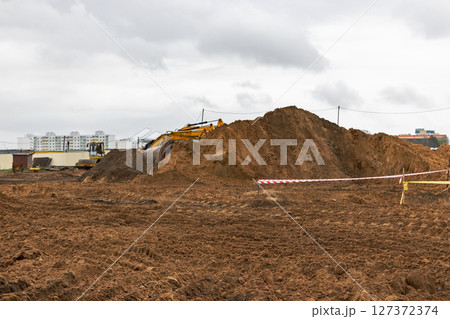 Soil on earth as texture and background. Warning or protective tape at a construction site. Soil on earth as texture and background. Warning or protective tape at a construction site. 127372374