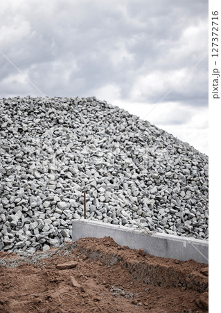 Pile of gravel at construction site with cloudy sky in the background during daylight hours Pile of gravel at construction site with cloudy sky in the background during daylight hours 127372716