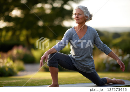 Senior woman doing yoga in a garden 127373456