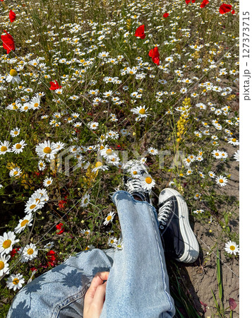 Relaxing in a Field of Daisies and Poppies 127373715