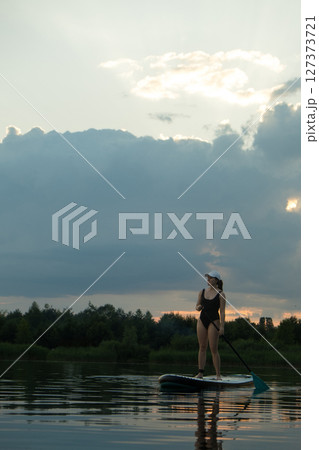 Paddleboarding at Sunset on a Tranquil Lake 127373721